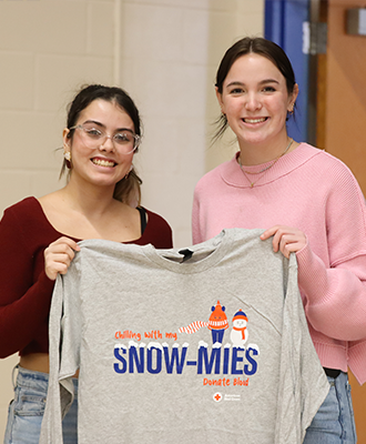  Students hold a gray t-shirt from the American Red Cross