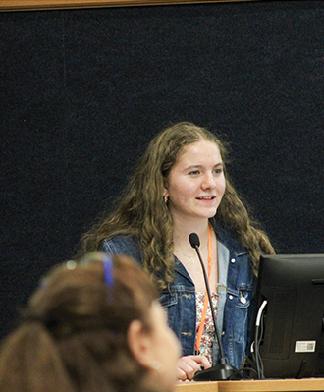  A student giving a presentation in front of an auditorium 